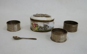 Three silver napkin rings and a porcelain snuff box of oval form, the top of the hinged cover