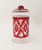 An early 20th century Bohemian ruby red cut glass lidded jar with etched diamond and scrollwork