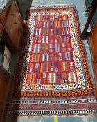 Modern Eastern-style rug with red ground central field in whites, oranges, blues, greens and reds
