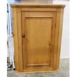 Pine wall-hanging corner cupboard with single door enclosing shelves, 106cm high