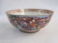 Chinese Canton porcelain bowl painted with panels of figures beside a lake, on an orange brocade