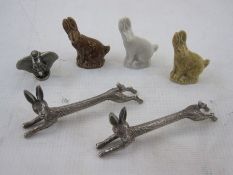 A pair of silver plated hare knife rests, three Wade china hares and a metal figure of Dumbo