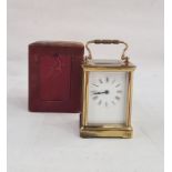 Brass and five-sided glass carriage clock in leather carry case, with Roman numerals to the dial,