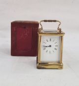 Brass and five-sided glass carriage clock in leather carry case, with Roman numerals to the dial,