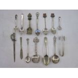 Assortment of silver and white metal spoons, sugar tongs and souvenir ware