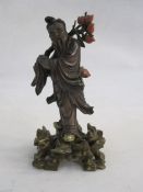 Chinese carved and partly lacquered wood standing figure of a sage holding flowering lotus branch,