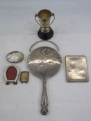 Silver-backed hand mirror embossed floral swags, a small two-handled prize cup, an engine-turned