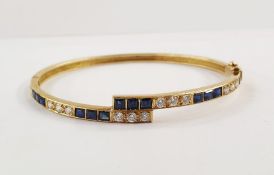 18ct gold, sapphire and diamond bangle, fine crossover pattern and set with 14 square-cut