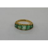 Emerald dress ring set five emerald cut stones interspersed with small old cut diamonds, in scroll