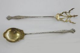 Pair of American late 19th century sterling silver-gilt serving spoons, the fork with scroll