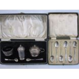 Three-piece silver condiment set, cased, two silver  salt spoons and a plated set of six shell bow