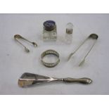 Silver-handled shoe horn, two pairs of sugar tongs, a silver napkin ring, a glass inkwell with