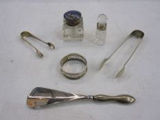 Silver-handled shoe horn, two pairs of sugar tongs, a silver napkin ring, a glass inkwell with
