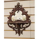 Possibly Victorian mirror with shaped glass plate in carved mahogany scrolling frame, with