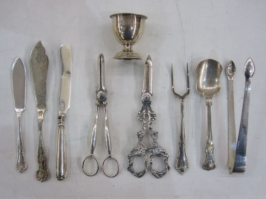 Silver eggcup, two pairs of grape scissors, sugar tongs, bread fork, etc (some items not silver)