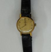 Lady’s rolled gold Omega De Ville wristwatch with baton numerals, side button and the skin strap