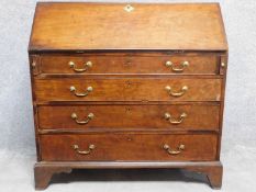 A Georgian mahogany bureau with fall front revealing fitted interior above four graduating drawers