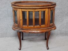 An Eastern carved teak vitrine cabinet with lift off oval tray. H.78 W.73 D.50cm