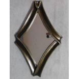 A contemporary bronzed frame diamond shaped Antigua wall mirror by Equipo Schuller. 65x102cm