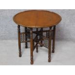 An Eastern folding occasional table with circular lift off oak top. H.54 W.61 D.61cm