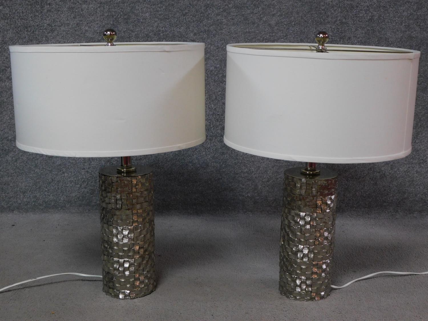 A pair of cylindrical textured metal table lamps with cross hatched design. H.60cm