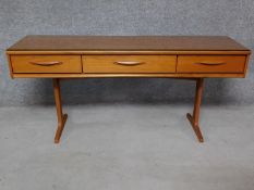 A 1970's vintage teak console sideboard fitted with frieze drawers on platform supports. H.71 W.