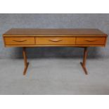 A 1970's vintage teak console sideboard fitted with frieze drawers on platform supports. H.71 W.