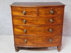 A Regency bowfronted flame mahogany chest of two short over three long graduated drawers fitted with