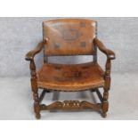 A mid 20th century Jacobean style oak armchair in embossed tan leather upholstery. 65cm