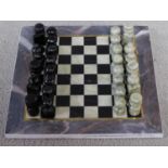 A vintage boxed Turkish carved hardstone chessboard and pieces. The pieces are made from a pale