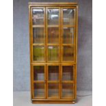 An American walnut floor standing brass bound library bookcase fitted with bevelled glass panel
