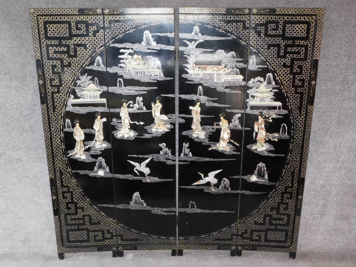 A Japanese mother of pearl and bone inlaid black lacquered three fold and four panel screen. H.183