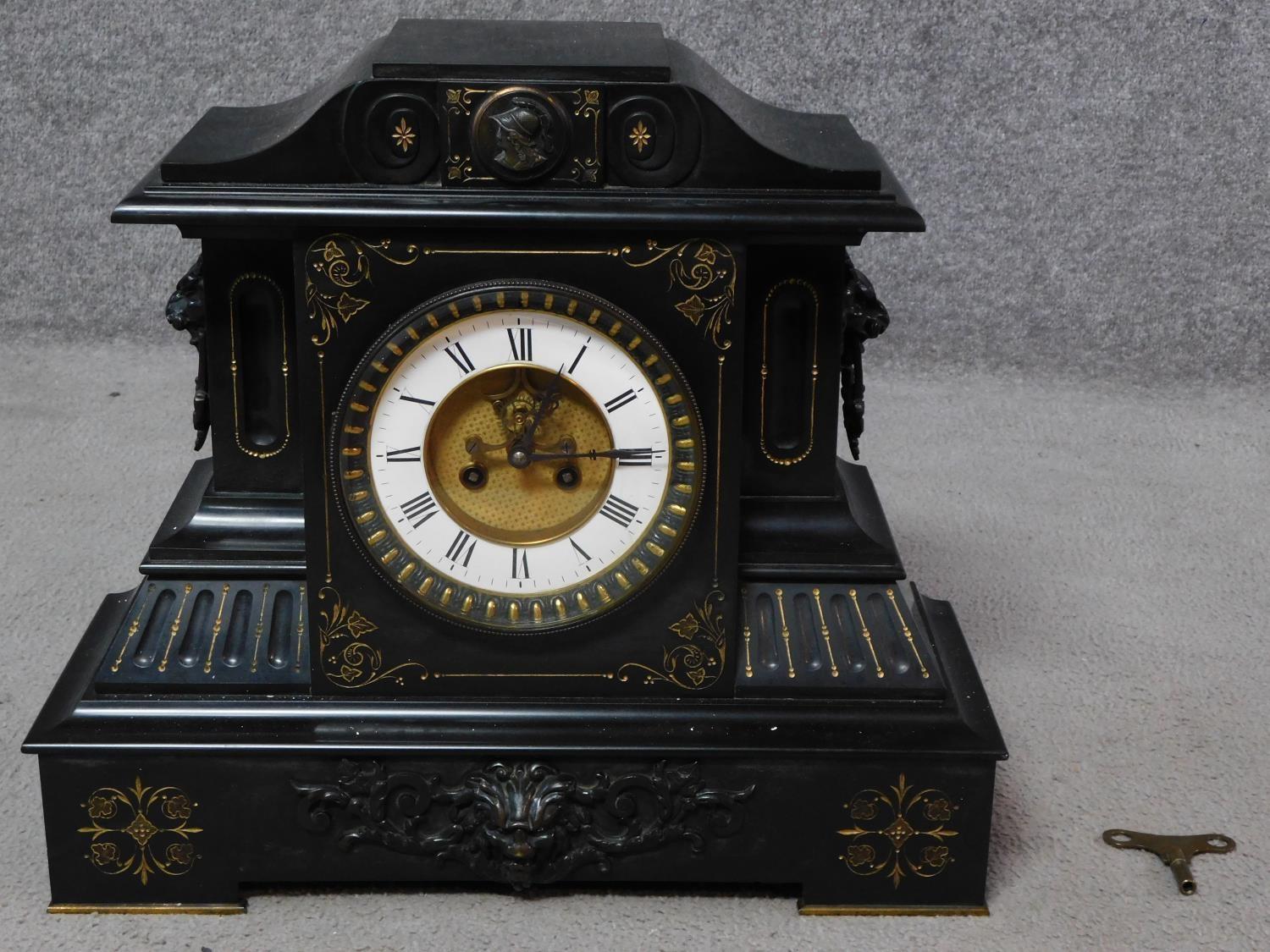 A large Victorian craved black slate mantel clock by Junghans. With engraved gilded foliate
