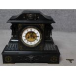A large Victorian craved black slate mantel clock by Junghans. With engraved gilded foliate