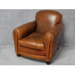 A vintage style club armchair in tan leather studded upholstery. H.86 W.82 D.90cm