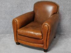 A vintage style club armchair in tan leather studded upholstery. H.86 W.82 D.90cm