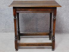 An antique country oak side table on turned stretchered supports. H.70 W.72 D.50cm