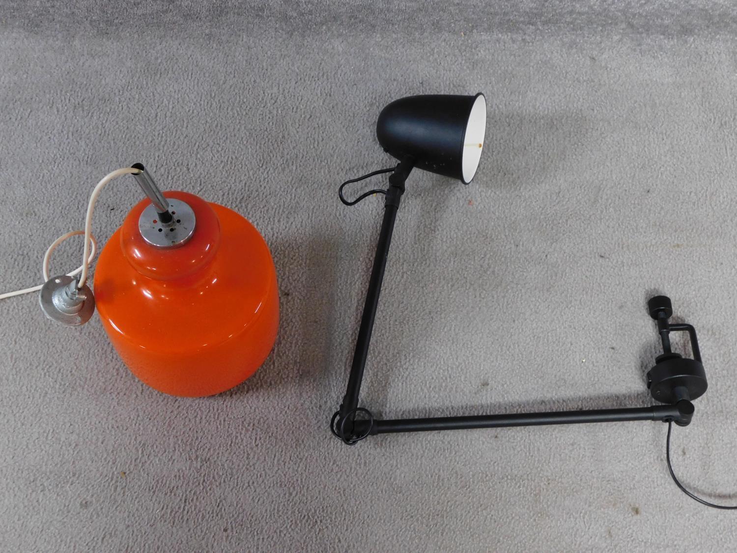 A vintage orange glass and chrome ceiling lamp along with a matte black metal screw on adjustable