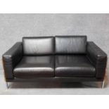 A two seater Robin Day Forum sofa in dark tan leather upholstery H.65 W.150 D.85cm