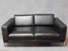A two seater Robin Day Forum sofa in dark tan leather upholstery H.65 W.150 D.85cm