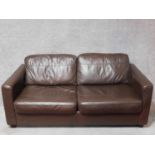 A dark tan leather upholstered two seater sofa bed. H.70 W.180 D.100cm (sofa)