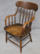 An American Colonial style oak stick back armchair on turned stretchered supports. H.88cm