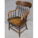 An American Colonial style oak stick back armchair on turned stretchered supports. H.88cm