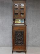 A late 19th century oak two section cabinet with well carved classical style panel door. H.211 W.