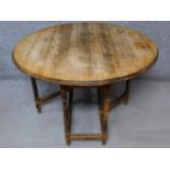 An antique style country oak drop flap dining table on turned stretchered supports. H.76 W.120 D.