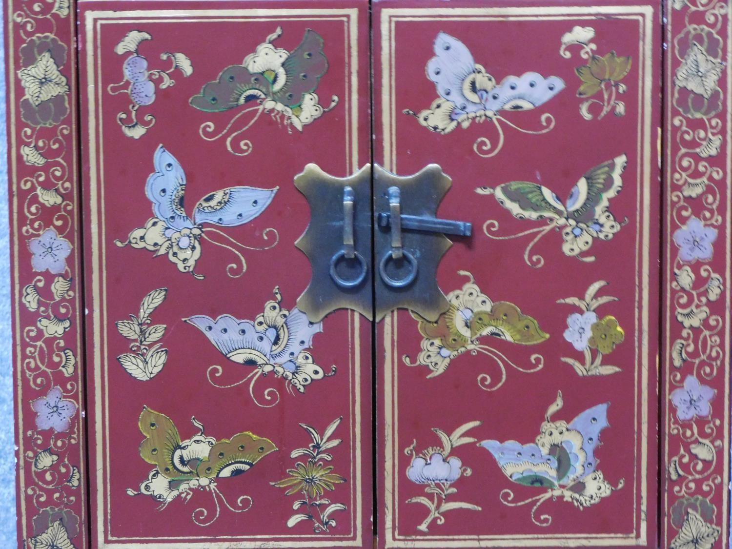 A Chinese red lacquered side cabinet with allover butterfly decoration. H.60 W.40 D.32cm - Image 6 of 6