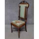 A Victorian carved rosewood side chair in tapestry upholstery on barleytwist stretchered supports.