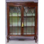 A late 19th century flame mahogany display cabinet with astragal glazed doors on cabriole