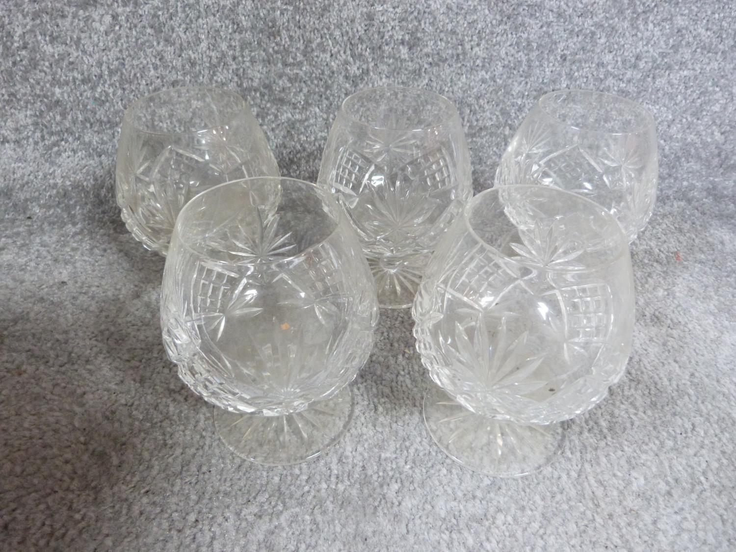 A set of five cut crystal stemmed whisky glasses with star cut bases. H12cm.