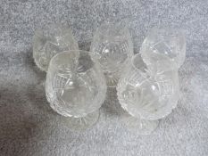 A set of five cut crystal stemmed whisky glasses with star cut bases. H12cm.